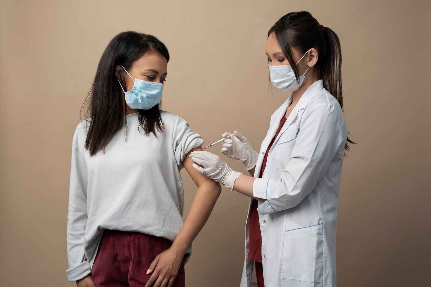 medium-shot-doctor-woman-with-masks_vaccine